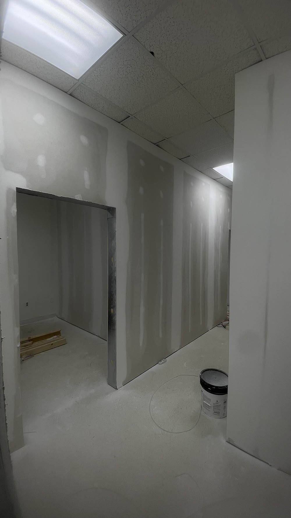 Corridor drywall taped, bedded, and floated with corner bead on opening